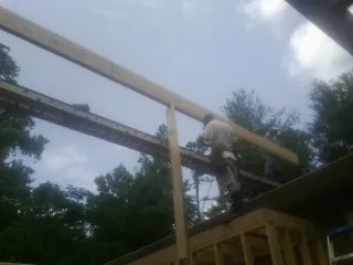 Carpenter setting a ridge beam over a new addition frame — Ice Dam Removal by Roofing Brothers in Hercules